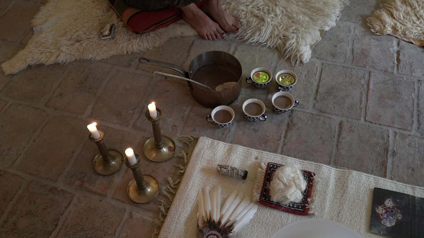 Candles, tea and ritual objects arranged on the floor